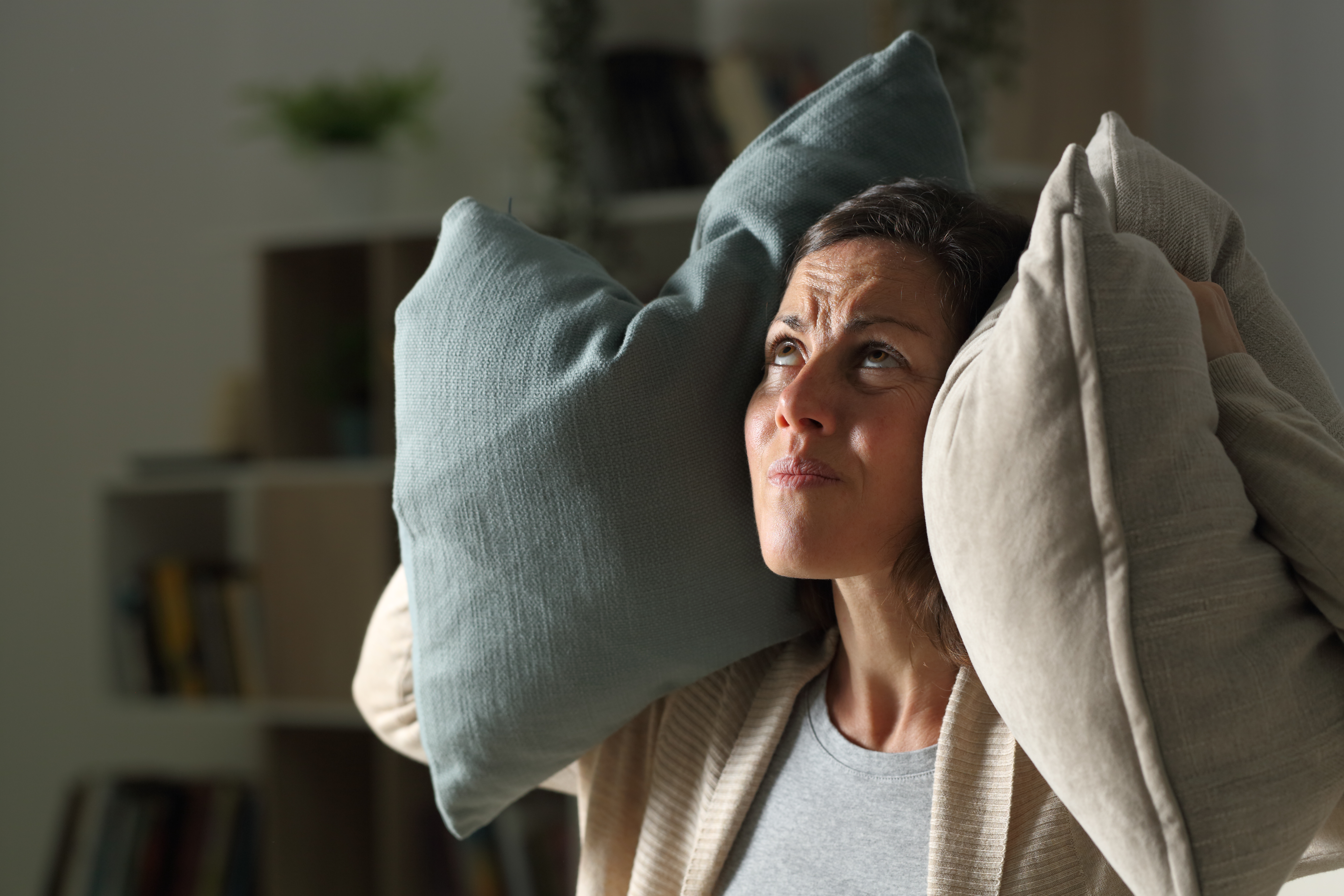 Lady with cushions covering her ears