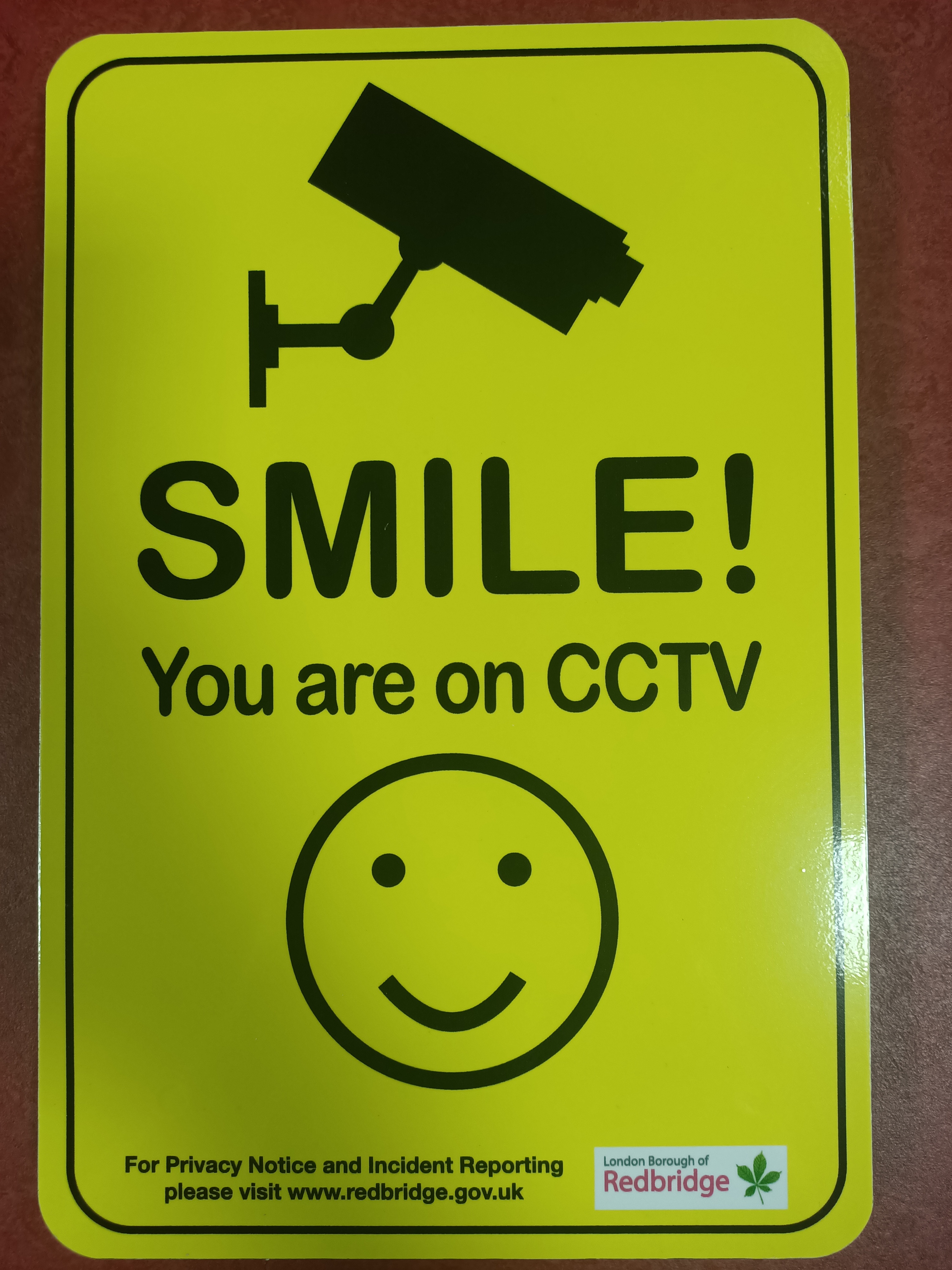 Yellow sign with big smiley face saying smile you're on CCTV